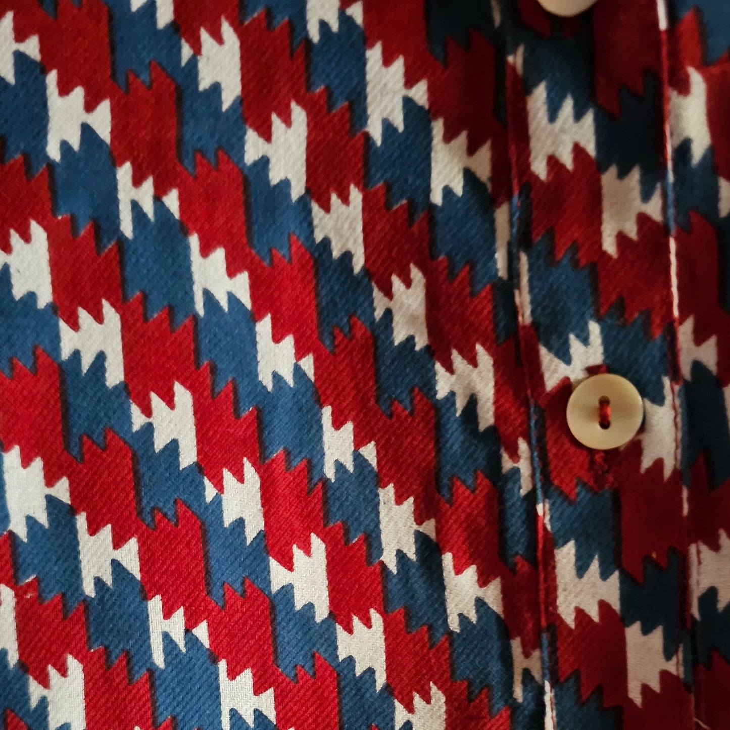 Close-up of a fabric with a red, white, and blue geometric pattern.