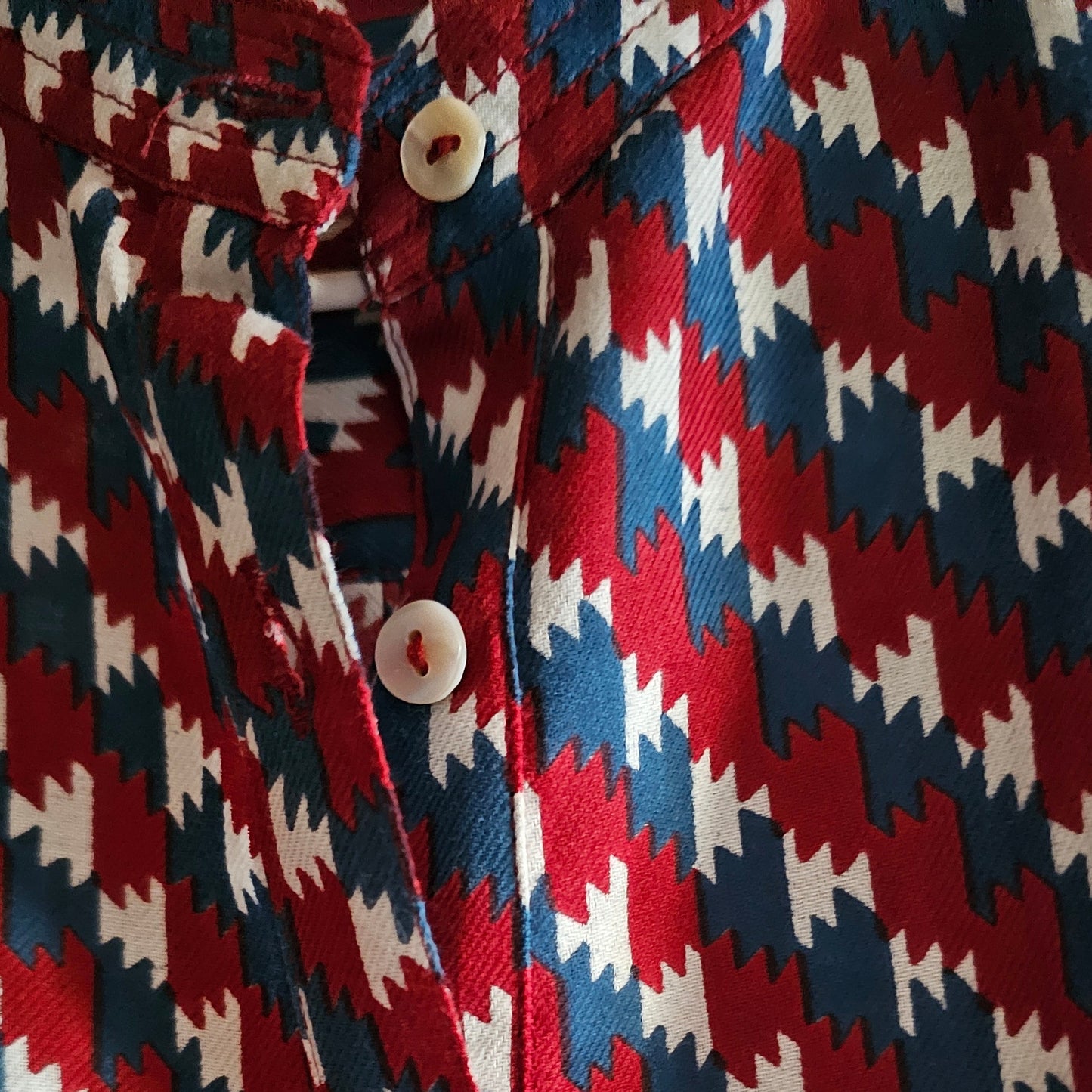 Close-up of a patterned fabric with red, blue, and white zigzag design.